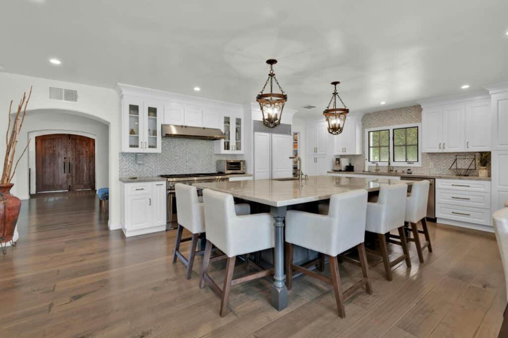 Bay Area Houston home value estimate featuring a spacious luxury kitchen with white cabinetry, large island, pendant lighting, and elegant modern finishes.